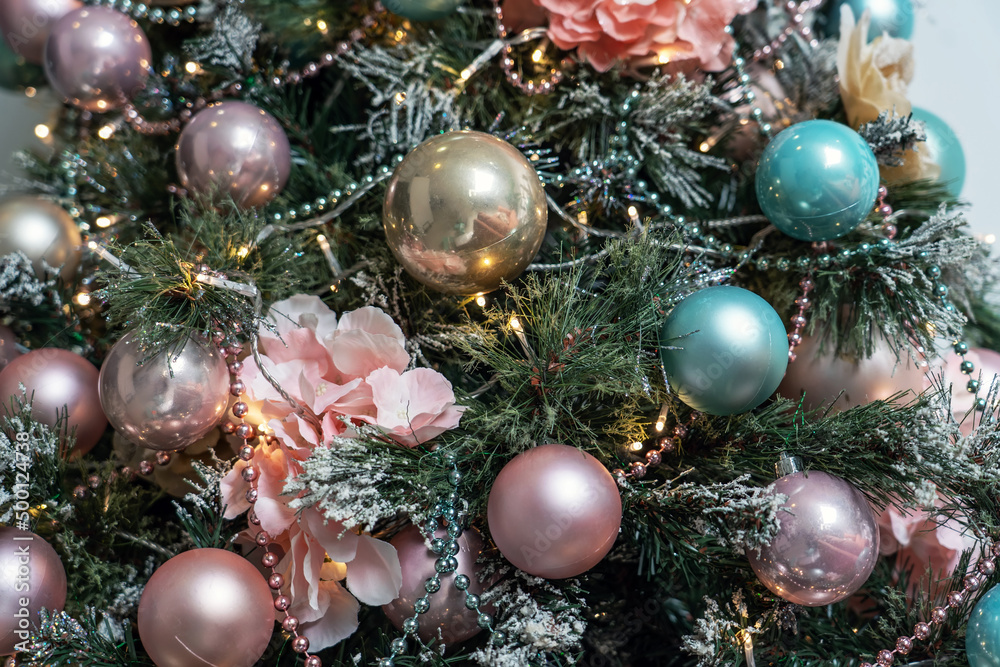 Close up view of Christmas tree branch with decorative balls, toys and shining garland. Christmas tree branchrs with balls. Christmas tree toy hanging on green snowy fir branch Close up view of Christmas tree branch with decorative balls, toys and shining garland. Christmas tree branchrs with balls. Christmas tree toy hanging on green snowy fir branch