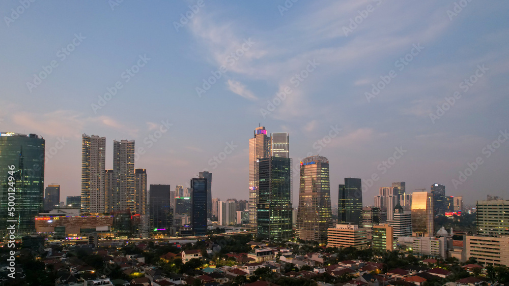 Aerial view of office buildings in Jakarta central business district and noise cloud when sunset. JAKARTA, INDONESIA - APRIL 21, 2022