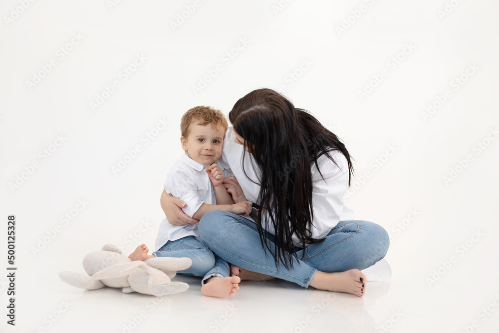 Studio shot of two people, woman and boy having fun and cuddling, talking to each other. Family weekend activity goals Studio shot of two people, woman and boy having fun and cuddling, talking to each other. Family weekend activity goals