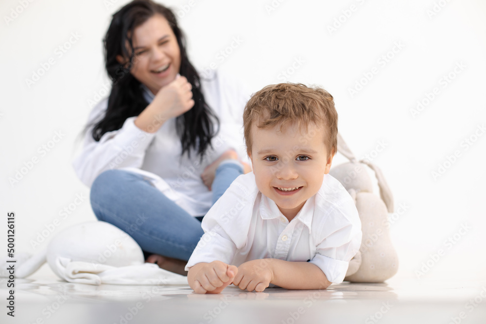 Photo of little fair haired boy lying on floor, near soft toy rabbit. Looking at camera, playing and mocking up, leisure Photo of little fair haired boy lying on floor, near soft toy rabbit. Looking at camera, playing and mocking up, leisure