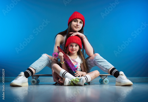 a young mother with her daughter on a skateboard and a longboard