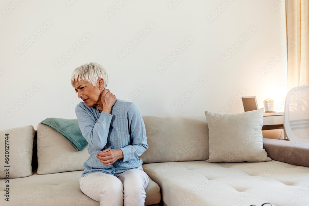 Mature woman with shoulder pain. Elderly woman is enduring awful ache. Shoulder pain in an elderly person. Beautiful lady with shoulder pain. Photo of senior woman holding her neck in pain.