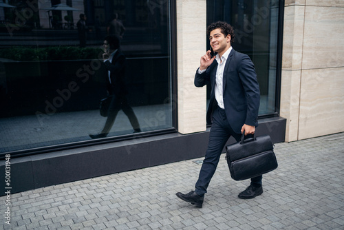 A male manager in a formal suit goes to work in the office