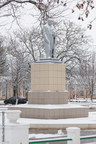 Taras Hryhorovych Shevchenko monument covered with snow at winter day with some trees on background photo