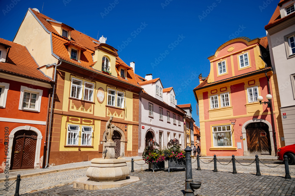 Cheb, Western Bohemia, Czech Republic, 14 August 2021: picturesque street with medieval colorful gothic houses, Fountain of St. Nicholas at Ruzovy kopecek at sunny summer day, baroque buildings