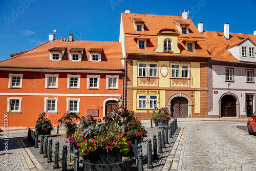 Cheb, Western Bohemia, Czech Republic, 14 August 2021: picturesque street with medieval colorful gothic houses, Fountain of St. Nicholas at Ruzovy kopecek at sunny summer day, baroque buildings photo