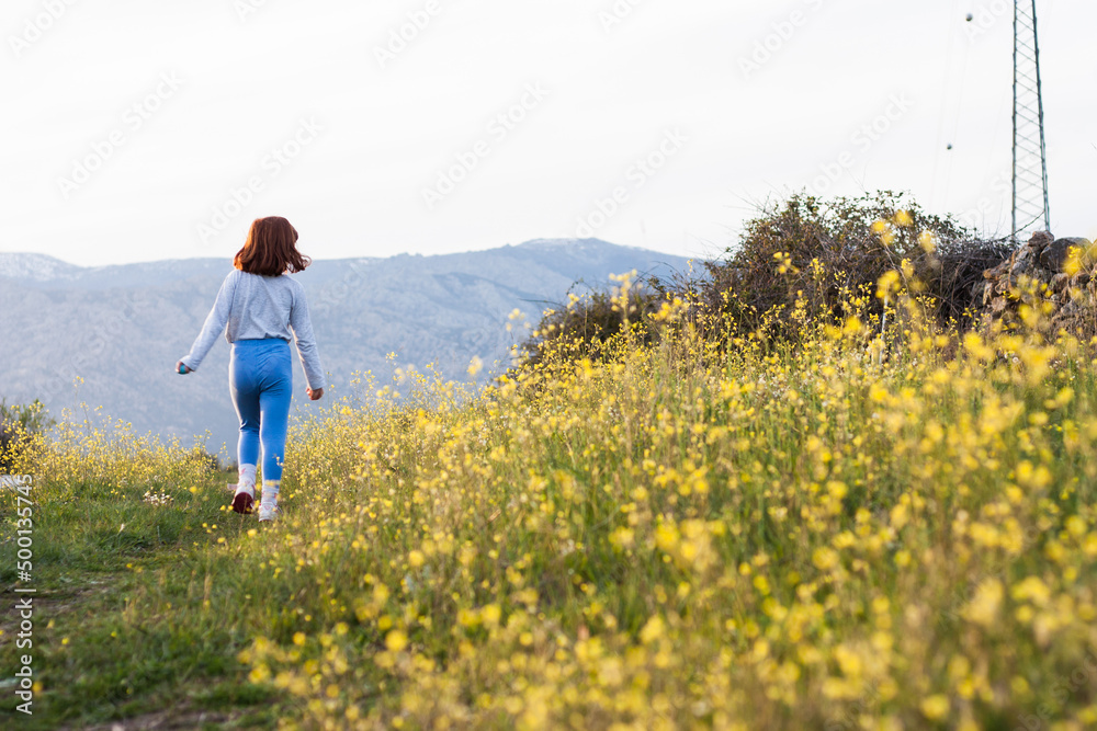 Chica jugando en el campo de flores amarillas