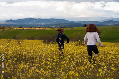 Niños jugando en el campo de flores amarillas © inmaleon79
