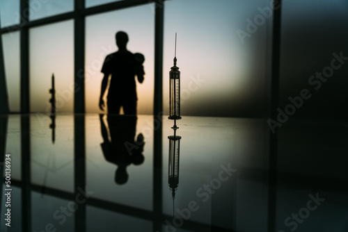 syringe with medicine on a background of sun light. concept of a new vaccine.