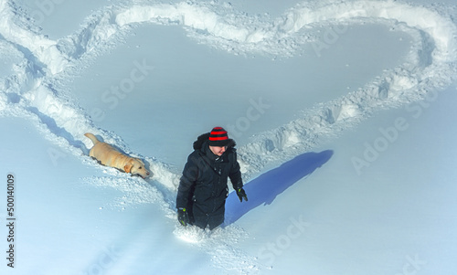 Boy and dog walking in deep snow