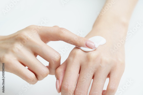 手にクリームを塗る女性