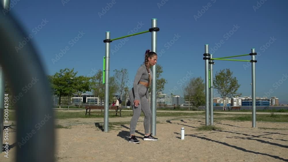 Athletic woman doing squats on the sports ground Athletic woman doing squats on the sports ground