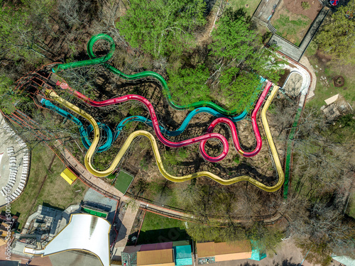 Aerial top down view of deserted abandoned red, yellow, blue, green long waterslides in an American amusement park photo