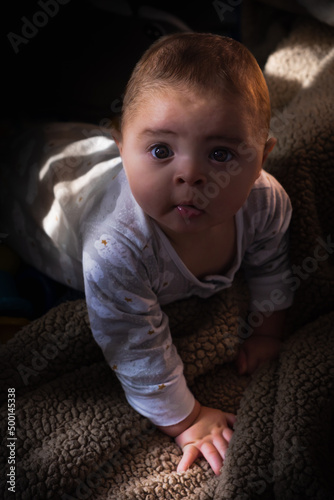 baby Child boy playing with toy indoors at home on the lifestyle  summer day at bed  latinamerican voy puertorican baby  photo