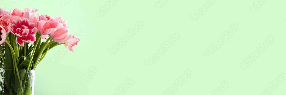 Fototapeta premium Vase with beautiful pink tulips flowers on color background with space for text