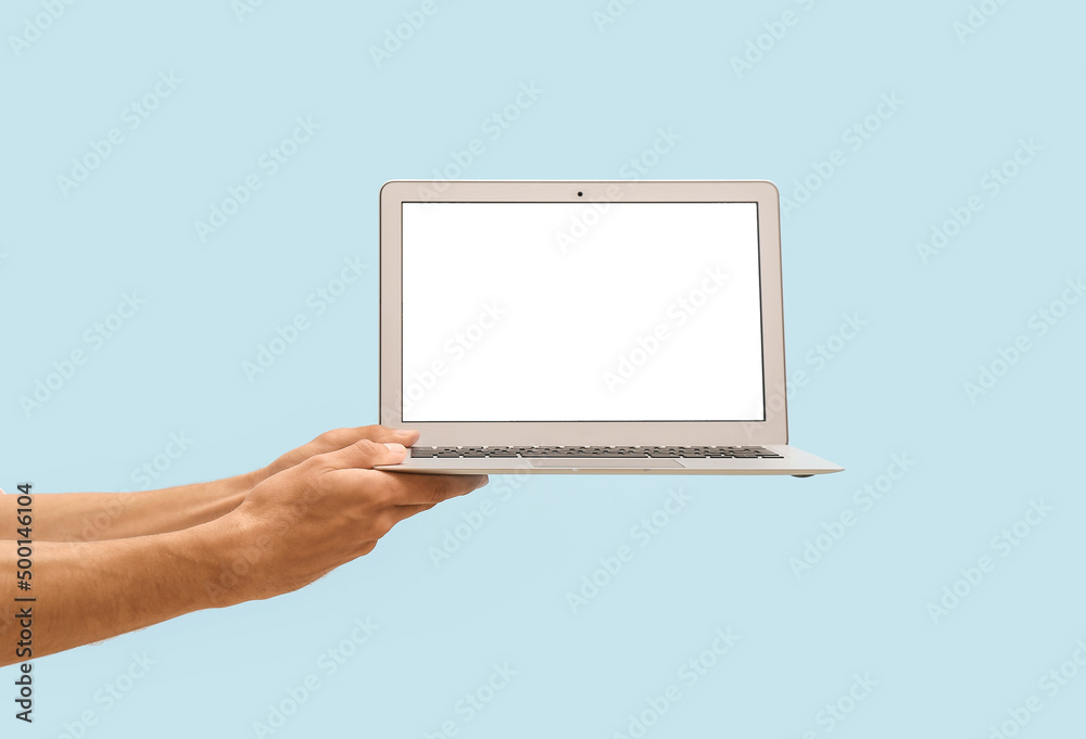 Male hands with modern laptop on color background Male hands with modern laptop on color background