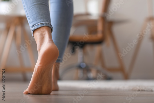 Bare foot of young woman walking at home, closeup © Pixel-Shot