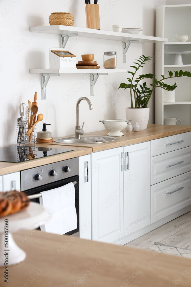 Counters with different utensils near white wall in kitchen Counters with different utensils near white wall in kitchen