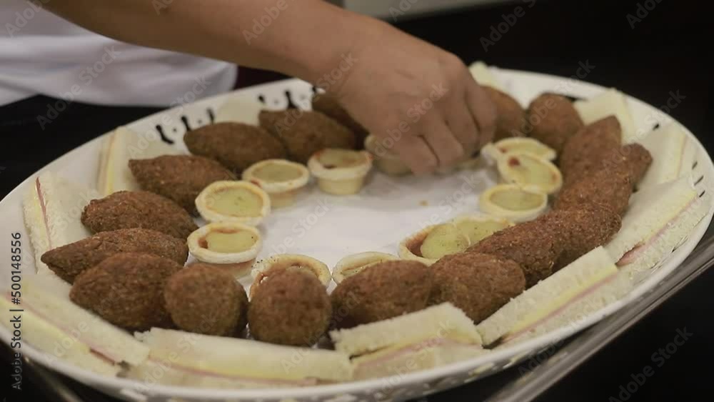 Joven empleada comodando pastelitos en bandeja de comida, Comida en casa para compartir en familia. Vista cerrada HD