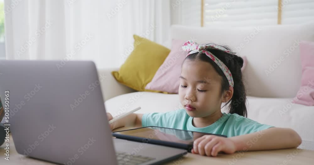 Cute pupil child gen z alpha girl sit talk video call self e-learning lesson on laptop at home sofa table. Asia art school tutor class drawing on tablet app enjoy fun social media upskill kid.