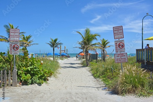 View of palm trees and beach from beach path leading to the ocean in Cocoa Beach, Florida near Cape Canaveral © Ryan Tishken