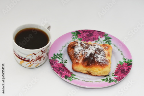  croissant on a white plate and a cup of coffee