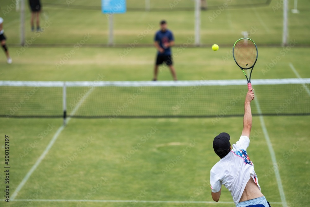 Amateur playing tennis at a tournament and match on grass in Melbourne, Australia