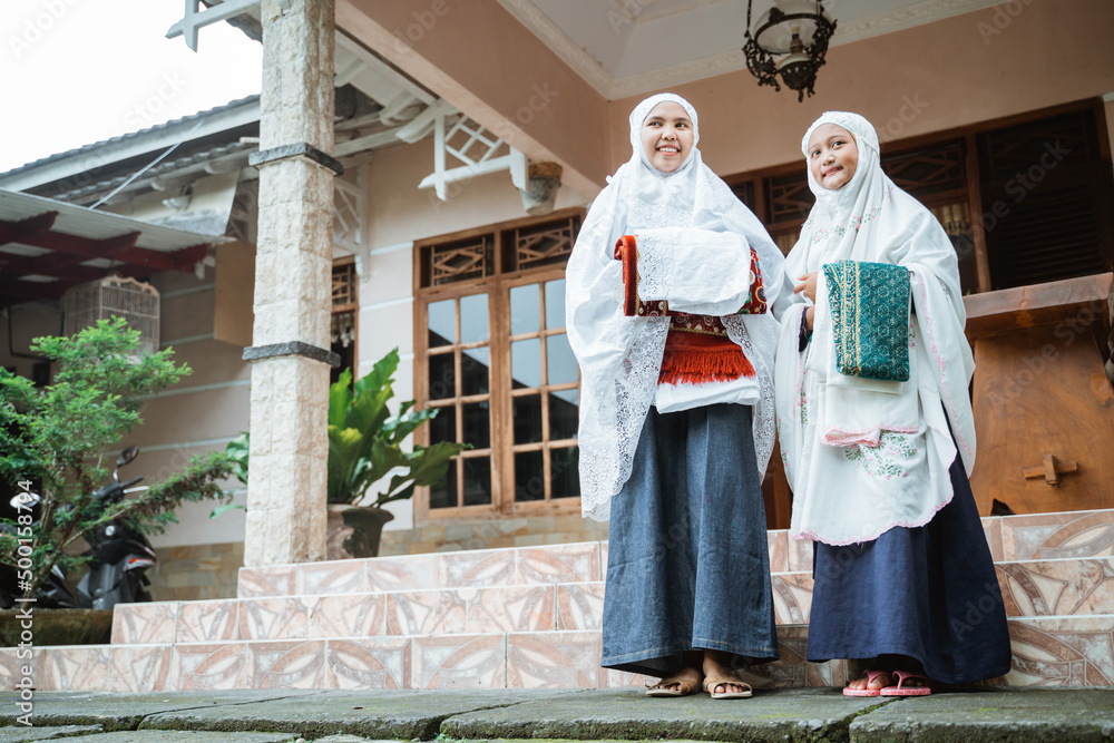 muslim mother and daughter getting ready to do idul fitri prayer together