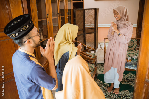 muslim woman welcoming guest's at home during idul fitri celebration