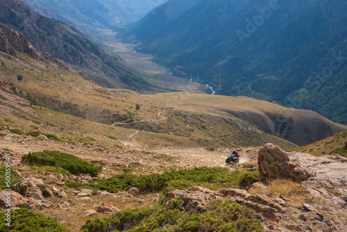 Mountain gravel road with ATV quadbike. Kapalskiy vzvoz mountain pass. Road to Burkhan-bulak waterfall. Travel, tourism in Kazakhstan. photo