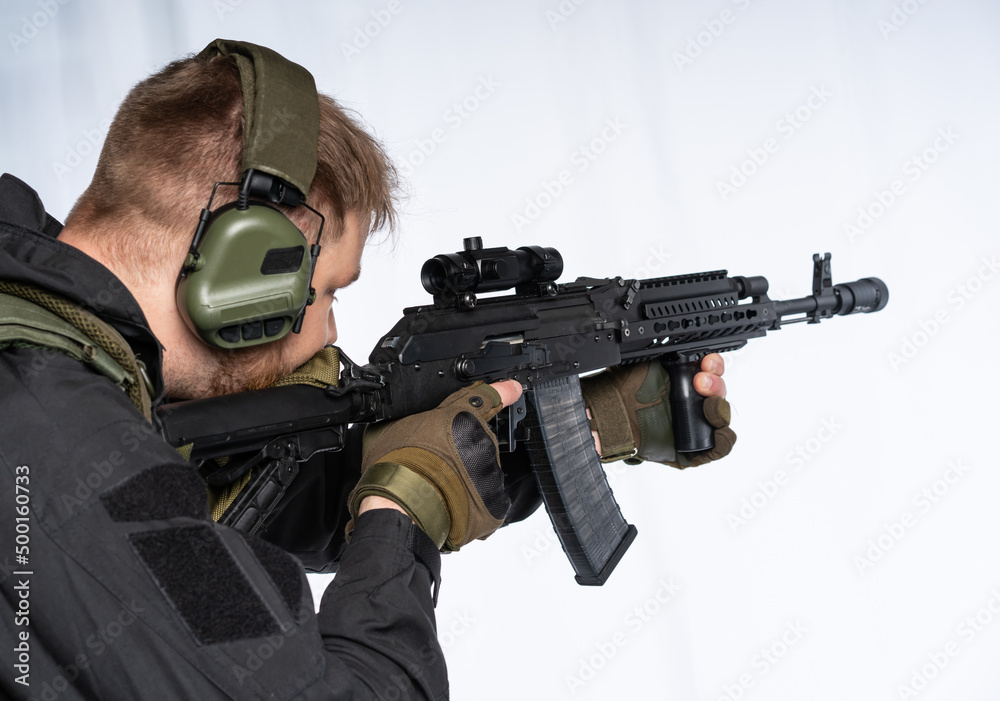 Airsoft player holds a rifle, a weapon with an optical sight. Soldier on alert. war concept. isolated background. Armed conflict. Russia Ukraine. military operation