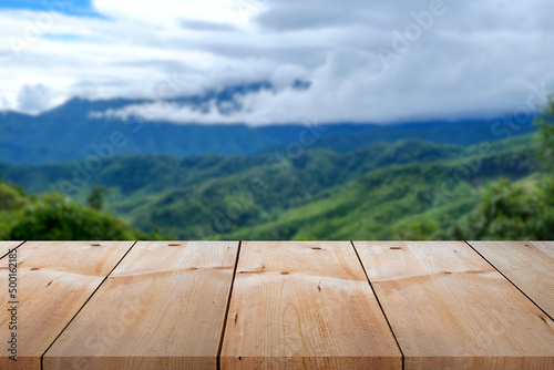 Close-up empty wooden plank long table top on vintage style for put product  with outdoor theme on blurred daylight landscape cloud and high mountain background