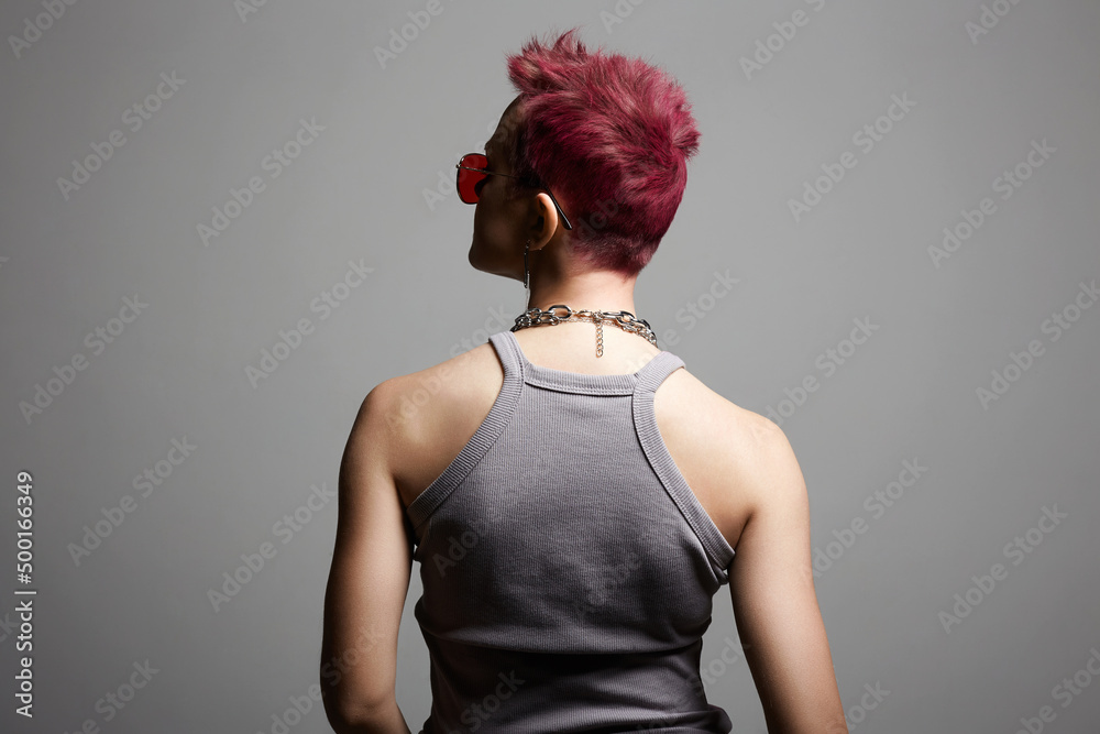 Female back. Young beautiful woman with painted short hair and a chain necklace