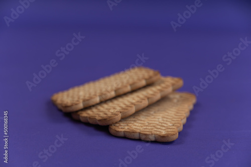 Three rectangular cookies against a blue background. Ready-to-eat treats with peanuts.