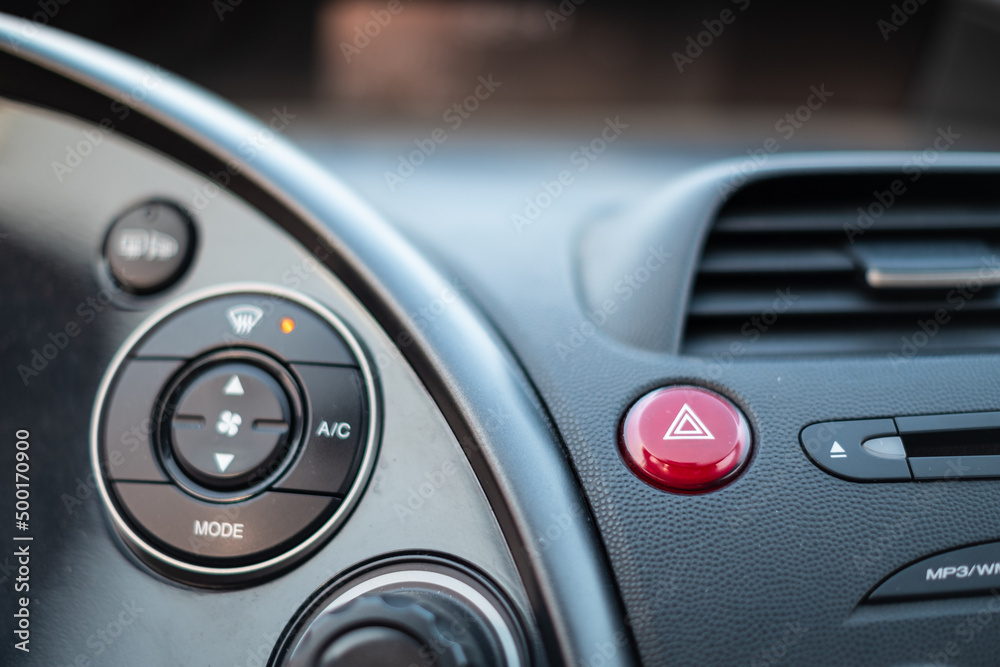 Red emergency button light in a dark car cockpit