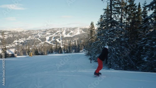 4k tracking of female snowboarder going downhill on a sunny winter day in Norway