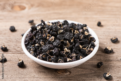 dry black wolfberry or black goji berries on wooden table