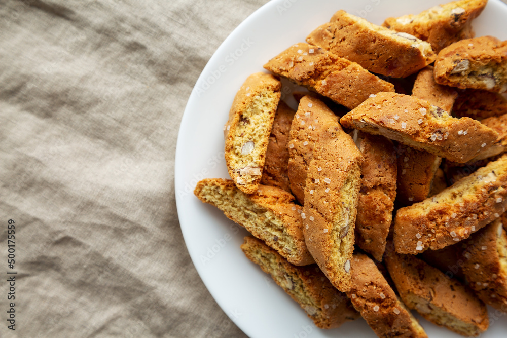Homemade Italian Cantuccini with Almonds on a White Plate, top view. Crispy Almond Cookies. Flat lay, overhead, from above. Copy space.