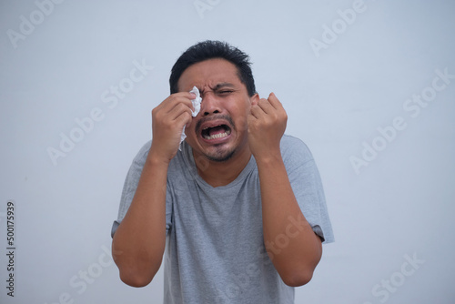 Fotografering man cry while wipe his tears