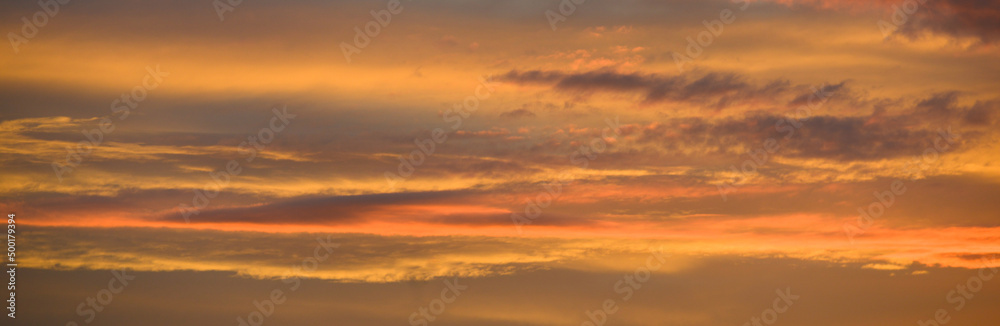 Panorama d'un ciel zen avec nuages colorés orange et jaune au coucher du soleil avec espace pour texte