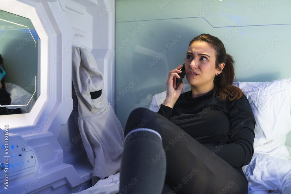 woman in capsule at night with the phone