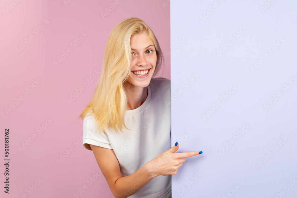 Woman pointing finger on blank board. Woman standing behind the banner or empty copy space advertisement board. Emotional girl. Woman pointing finger on blank board. Woman standing behind the banner or empty copy space advertisement board. Emotional girl.