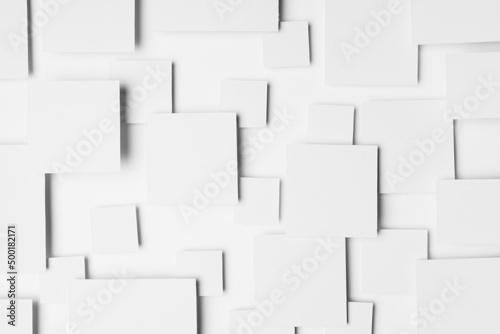 White abstract geometric background with paper squares in bright light with shadows  top view. Simple mosaic pattern in minimalist style.