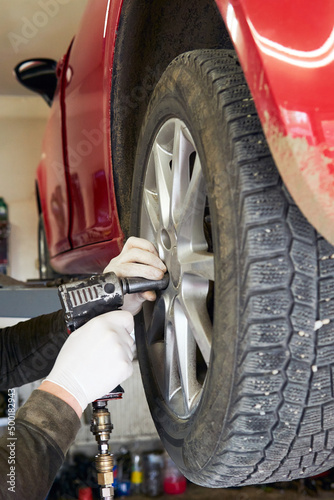 Mechanic removing a wheel from a car.