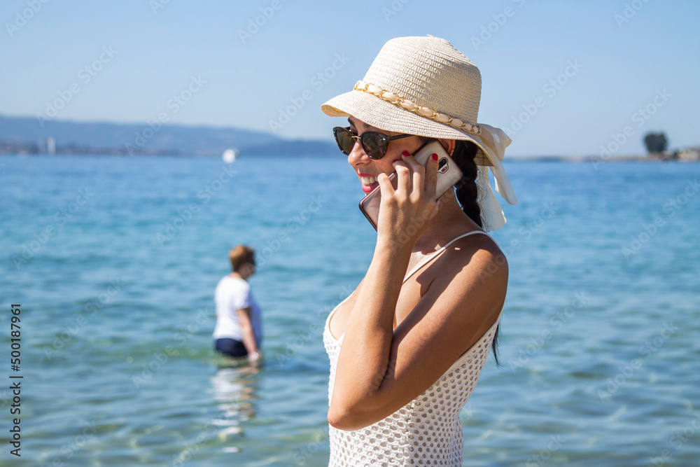happy young woman walking on the beach and talking on mobile phone happy young woman walking on the beach and talking on mobile phone