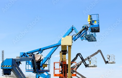 Wallpaper Mural Group of aerial working platforms of cherry picker against blue sky. Back and side view.	 Torontodigital.ca