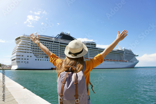 Tela Back view of traveler girl with raised arms standing in front of big cruise line