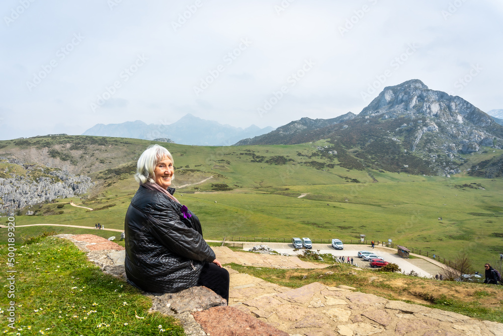 An elderly woman at the entrelagos viewpoint and Lake Ercina in the background in the Lakes of Covadonga. Asturias. Spain