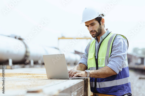 Heavy-duty industrial engineers stand in a pipeline manufacturing facility using digital tablet computers for the construction of products to transport oil, gas and fuel.