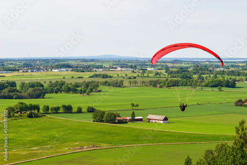 Aerial view at rural landscape in sweden with a paraglider